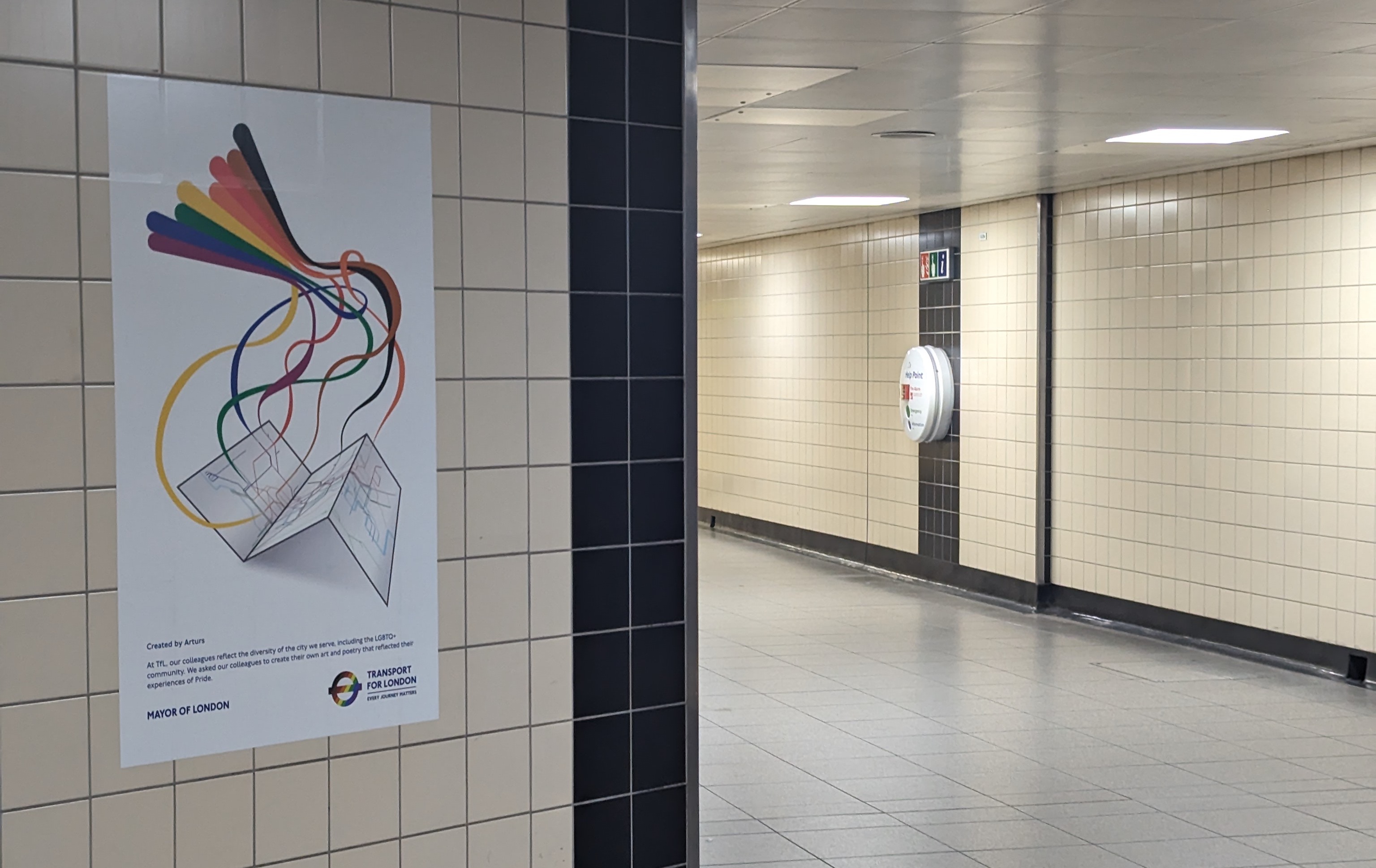 Photo of my pride poster in situ on a tiled wall at Vauxhall station